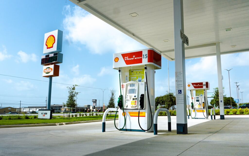 Gasolinera con surtidores de combustible y coche repostando
