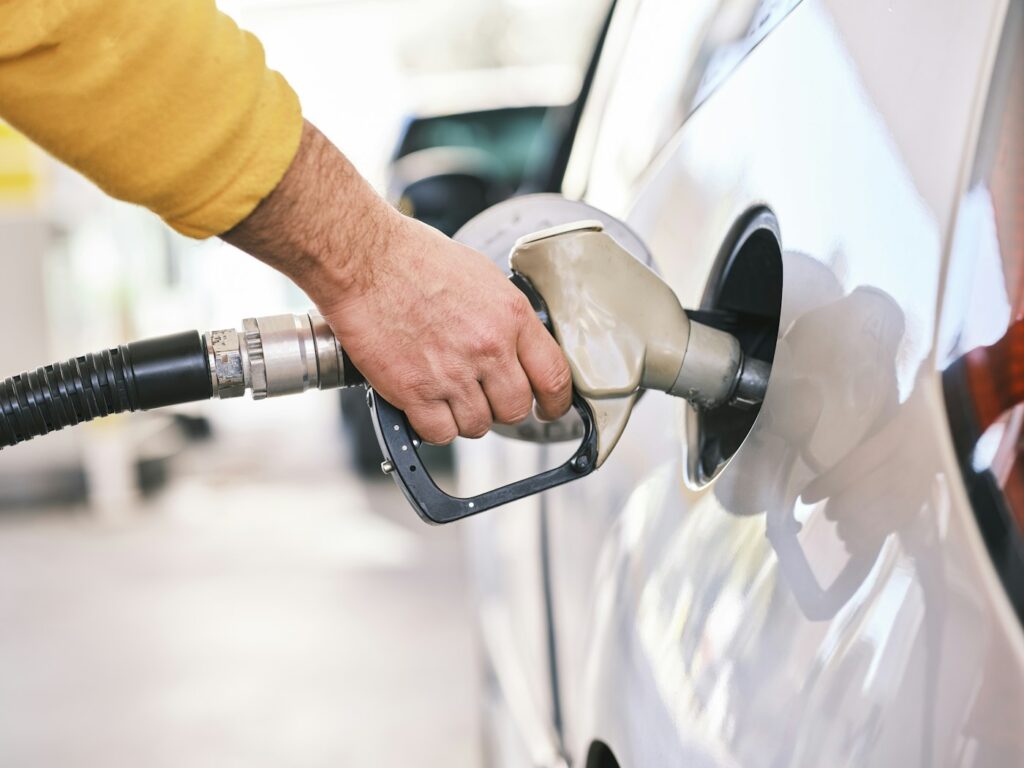 Persona repostando gasolina en una gasolinera